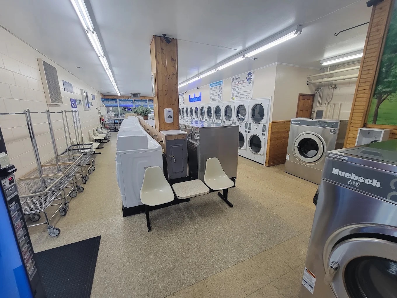 Clean interior of Layton Heights Laundromat with washers, carts and seating